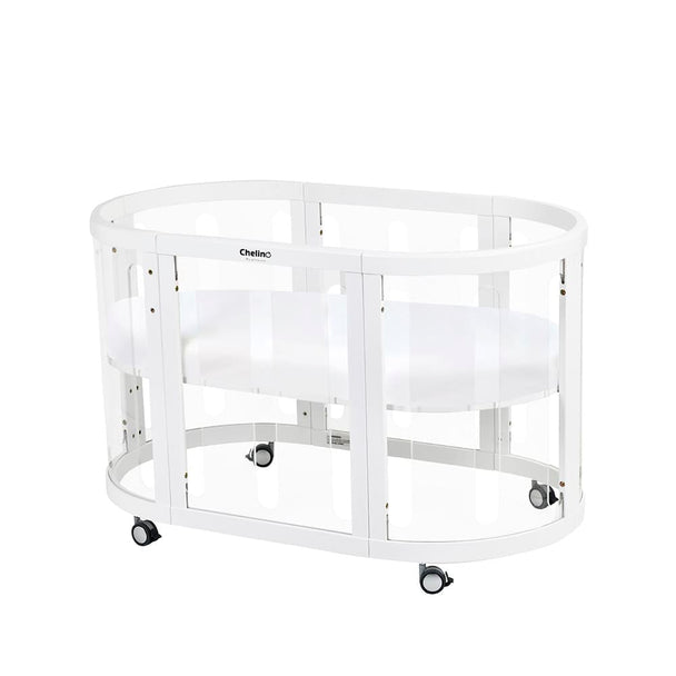 Selina 5 in 1 Cot White with clear panels and wheels, made from sustainable oak wood.
