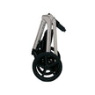 Lunar II Travel System in beige, folded, showcasing compact design and wheels.