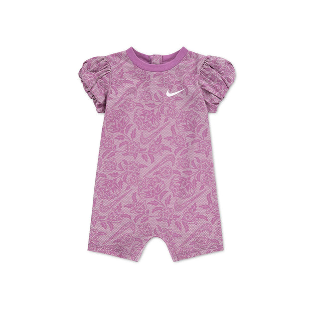 Nike NKG Lace It Up baby romper in pink patterned fabric, with puff sleeves, shorts legs and a white Swoosh logo.