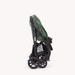 Joie Muze™ lx stroller folded with a sage green fabric canopy, black frame, mesh storage basket and cup holder