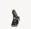 Joie Muze™ lx stroller in taupe fabric with a black frame, large wheels, storage basket and cup holder, folded compactly.
